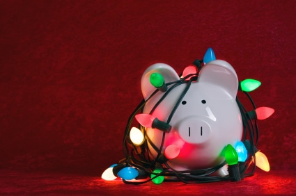 A piggy bank covered in christmas lights to save money for the holidays